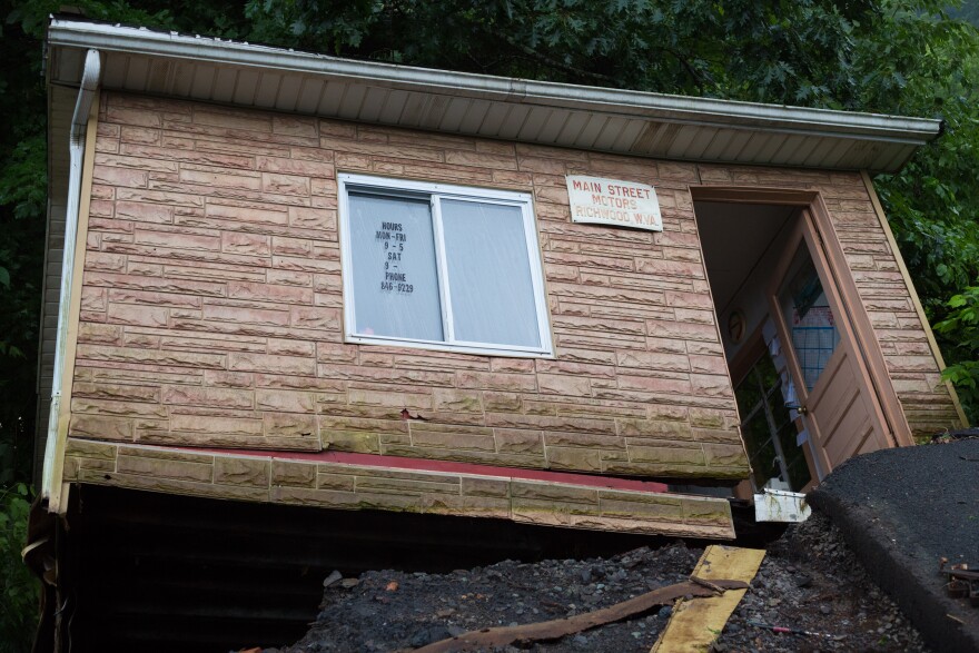 The Main Street Motors office building teeters off the side of the road in Richmond, WV, after the ground beneath it collapsed due to heavy rains Thursday.