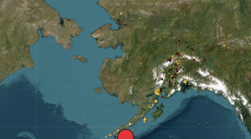 The magnitude 7.3 earthquake (largest red dot) occurred south of Sand Point.