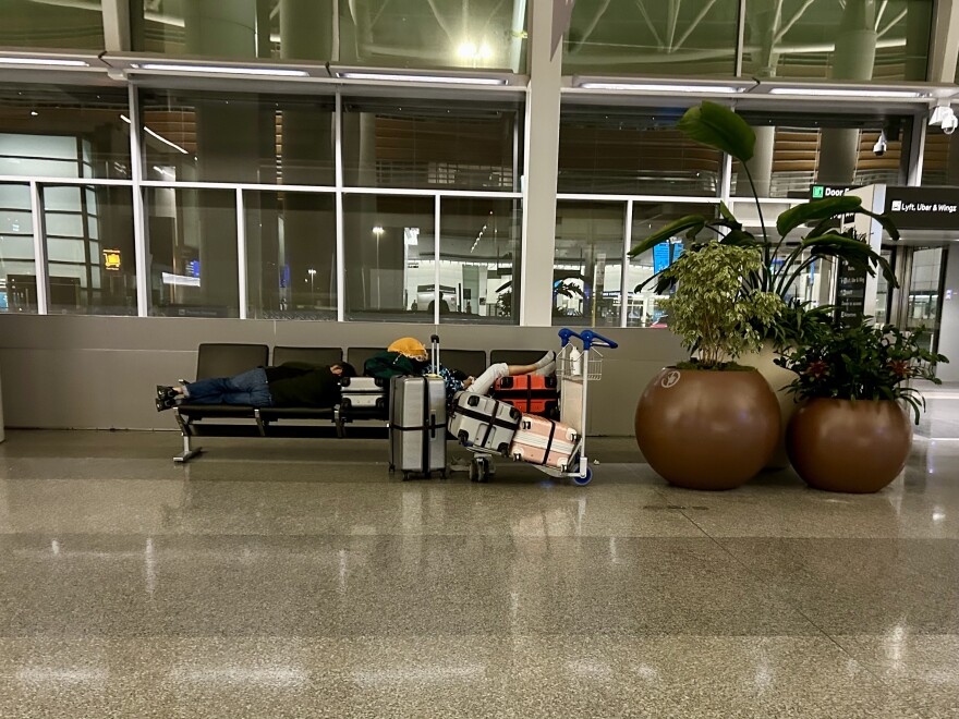 Passengers sleep on their luggage in SFO's International Terminal before 5 a.m.
