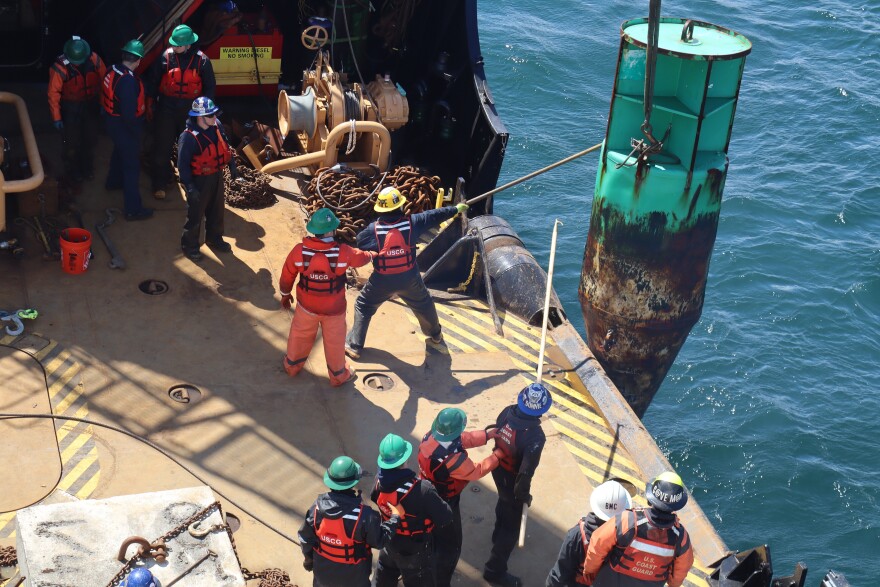 U.S. Coast Guard crew sets a replacement buoy from the Cutter Cypress.