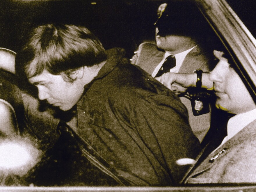 John Hinckley Jr. in 1981, escorted by police in Washington, D.C., following his arrest after shooting and seriously wounding then-President Ronald Reagan. He was found not guilty by reason of insanity.