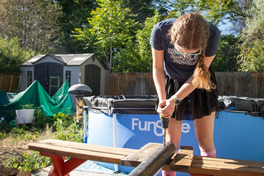 Barnes drills into a 12-foot post for a backyard shade sail.