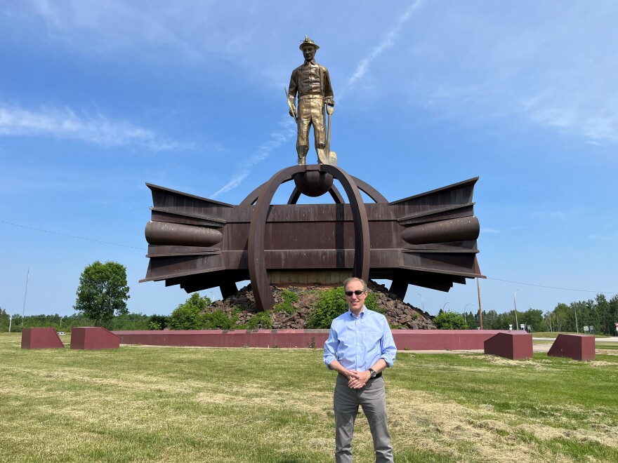 Minn. Secretary of State Steve Simon stands in front of the Iron Man Memorial Statue in Chisholm.