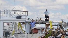 Boaters inspect what's left of their vessels, which were swept by storm surge more than 100 feet inland from Matanzas Pass onto San Carlos Island days after Hurricane Ian made landfall in Lee County on Sept. 28, 2022