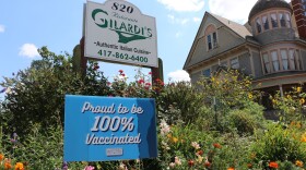 A sign is displayed in front of a local business touting its staff's vaccination rate