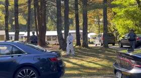 In this image taken from video, New York State police and crime scene investigators walk across the property, Tuesday, Oct. 3, 2023, in Milton, N.Y., where Craig N. Ross Jr. was found with 9-year-old Charlotte Sena, who he is suspected of kidnapping. A fingerprint on a ransom note led police to the kidnapping suspect's camper in New York where Sena was found hidden in a cabinet, ending a two-day search sparked by the girl's disappearance during a family camping trip, officials said. (AP Photo/Maysoon Kahn)