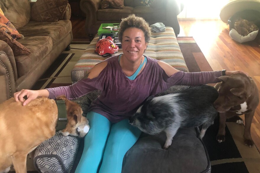 Dr. Cari Croghan sitting with her pets in her home.