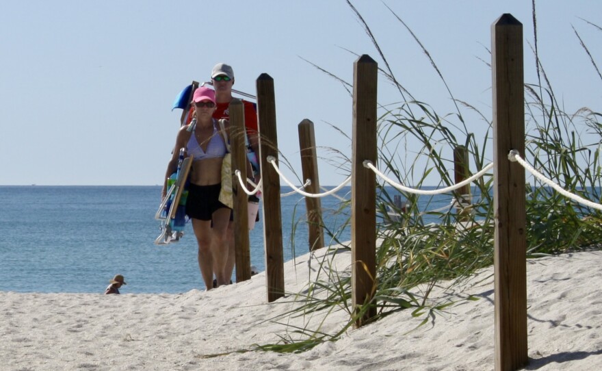 Ropes and wooden bollards line dunes on Barefoot Beach to prevent beachgoers from trampling on the vegetation.