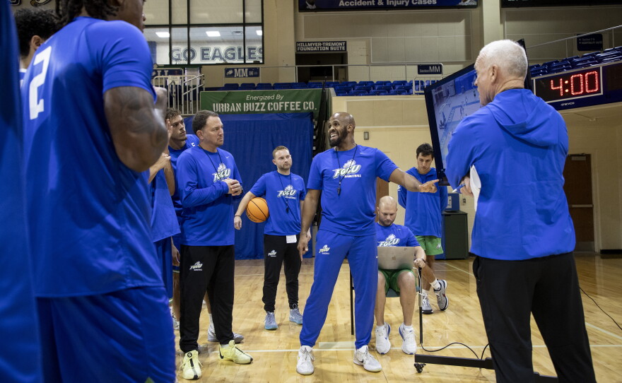 FGCU associate head coach DJ Irving goes over a scrimmage recording with mens basketball players at their first official practice of the 2026-2027 season.