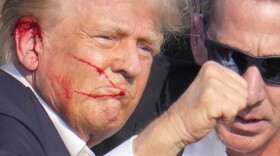 Republican presidential candidate former President Donald Trump gestures while surrounded by U.S. Secret Service agents as he is helped off the stage at a campaign rally in Butler, Pa., Saturday, July 13, 2024. (AP Photo/Gene J. Puskar)