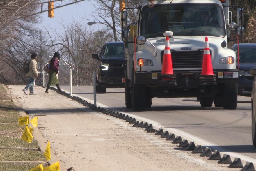 Current bike lane barriers on East Third Street include poles and rubber stops.