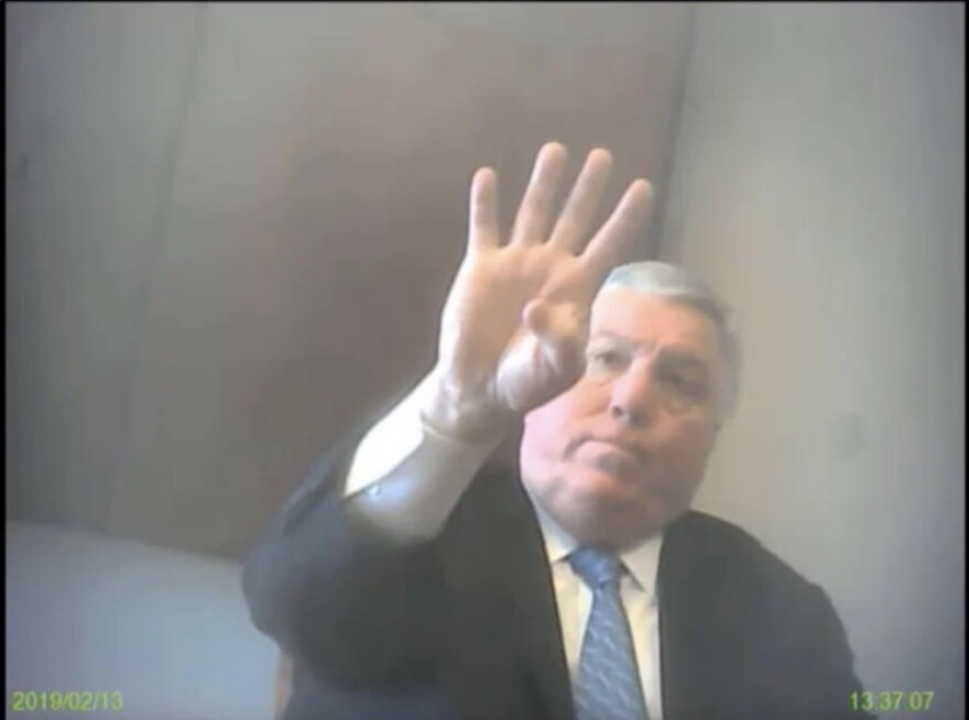 Then-City Club President Jay Doherty appears in a secret FBI video recorded by Fidel Marquez in February 2019. Doherty, a larger white man wearing a suit holds up four fingers -- he's positioned above the camera.