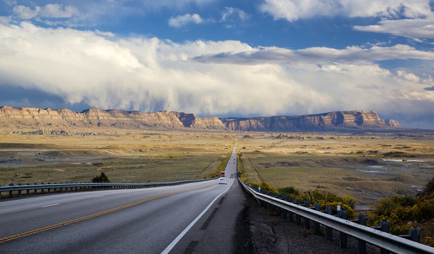 A photo of a road leading to the Book Cliffs up ahead.