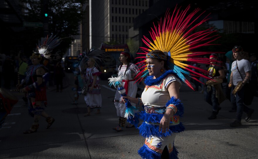 Martha Cano, a member of the CeAtl Tonalli Aztec dance group, leads the annual March for Immigrant and Workers Rights on Tuesday, May 1, 2018, in Seattle. 