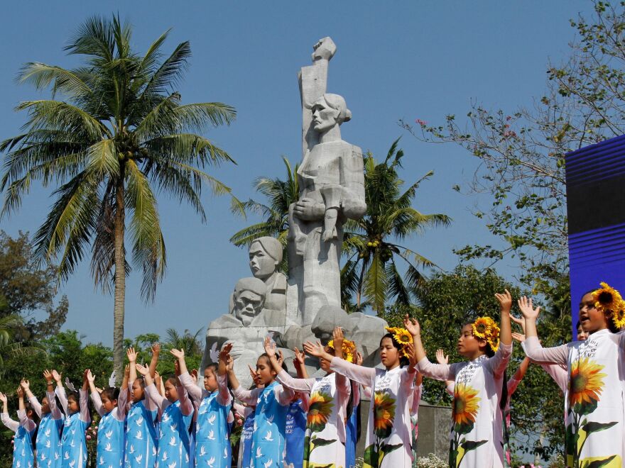 Children perform at a war memorial dedicated to the victims of the My Lai massacre in the village of Son My during a ceremony marking the 50th anniversary of the massacre on March 16, 2018.