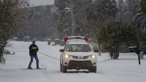 Sid Rismani skis behind a car on Waterway Blvd. while heavy snow comes down on the Isle of Palms, S.C., Wednesday, Jan. 3, 2018. A brutal winter storm dumped snow in Tallahassee, Florida, on Wednesday for the first time in nearly three decades before slogging up the Atlantic coast and smacking Southern cities such as Savannah and Charleston, South Carolina, with a rare blast of snow and ice. (AP Photo/Mic Smith)