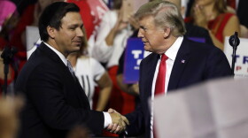  In this July 31, 2018, file photo, President Donald Trump (right) shakes hands with Florida Republican gubernatorial candidate Ron DeSantis during a rally in Tampa, Fla. 