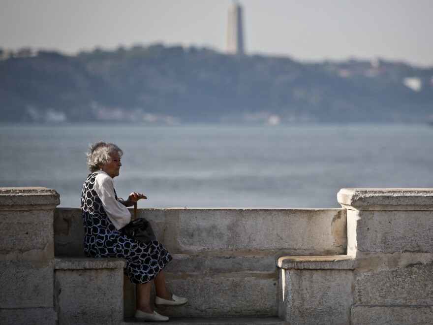 An elderly woman sits near the Tejo River in Lisbon on Oct. 17, 2011. Portugal's population is aging rapidly, due to a drop in births coupled with growth in emigration.