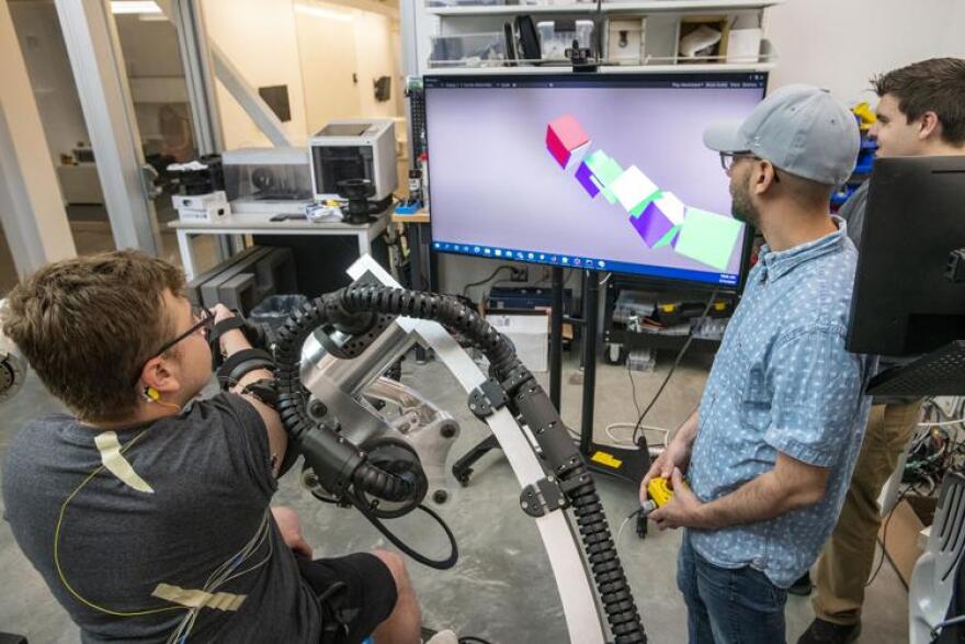 University of Idaho students Sebastian Rueda, from left, Rene Maura and Chris Bitikofer test functionality of a device called "Blue Sabino," which stands for Bilateral Upper-limb Exoskeleton for Simultaneous Assessment of Biomechanical and Neuromuscular Output. The Device is used to measure arm mobility of stroke patients. Photo Courtesy Zach Wilkinson/The Lewiston Tribune