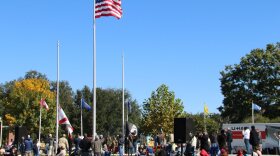 La multitud observa cómo se alza una nueva bandera en el nuevo mástil de bandera dedicado a los veteranos que han fallecido. Foto por: Marina Meretz.