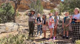From left, Colorado National Monument Ranger Amber Martin points out plants and wildlife to Brynleigh, 11; Angelique, 9; Lili, 9; Saga, 11; Levi, 9; and Rileigh, 11, during a hike at the monument on June 17, 2025. The children visited Colorado National Monument with Riverside Educational Center in Grand Junction to participate in the monument’s Resiliency Ranger program, which Martin oversees.