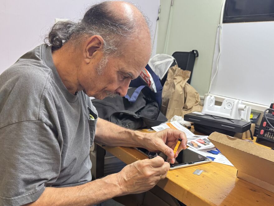 Joe Dipietro repairs a tablet with a broken screen.
