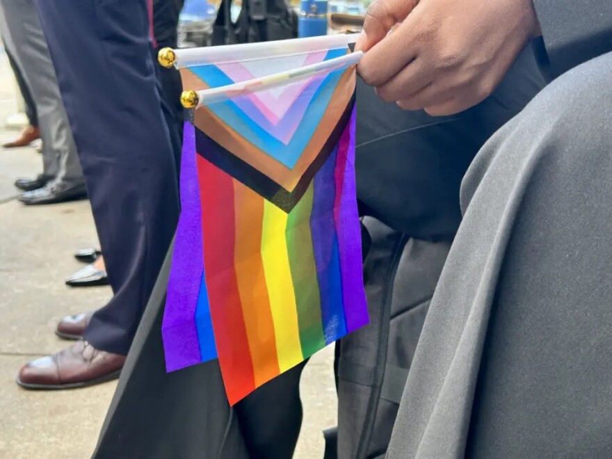 Flags in support of the LGBTQ+ community are held outside a federal courthouse in Houston on Thursday, Dec. 18, 2025.