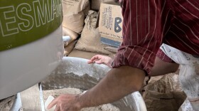 large mixer with dough in it, Max Meier reaching in with scraper