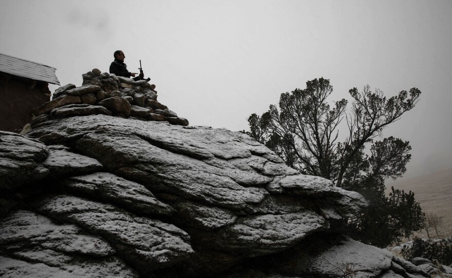 Drew Miller shows visitors a view from one of the guard positions on the ranch.