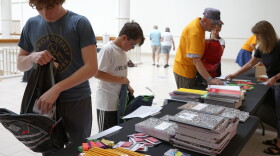 Volunteers stuff some of the more than 300 backpacks to be distributed Monday at Ellsworth Avenue School.