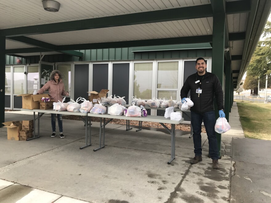 El personal de Communities in Schools, del que hace parte Robert Ramírez (derecha), organizó esta distribución de alimentos en la escuela secundaria Hug en marzo de 2020. Hasta junio, se repartieron 75 bolsas de comida semanalmente en este lugar.
