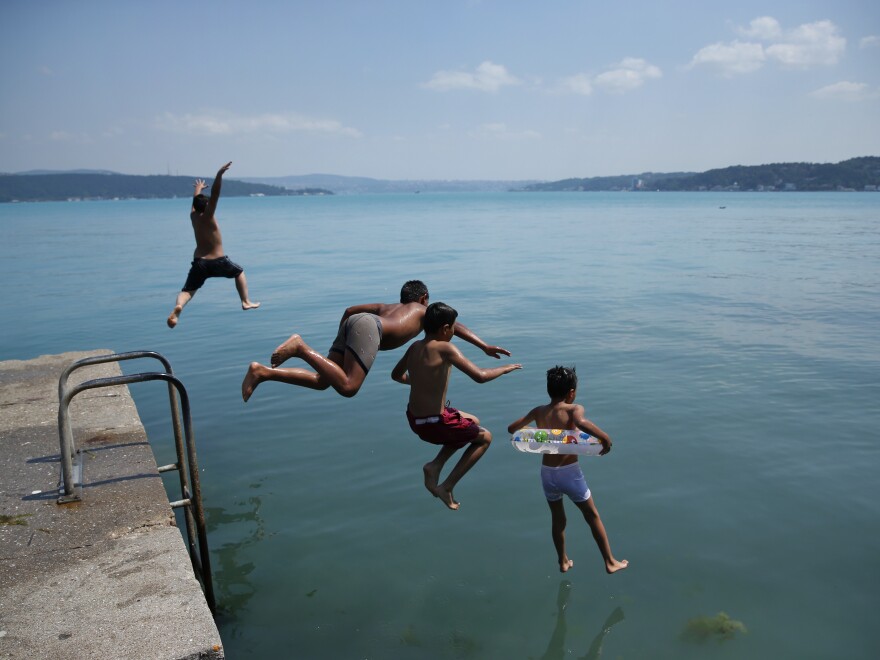 Children jump into Istanbul's Bosphorus Strait on Wednesday.