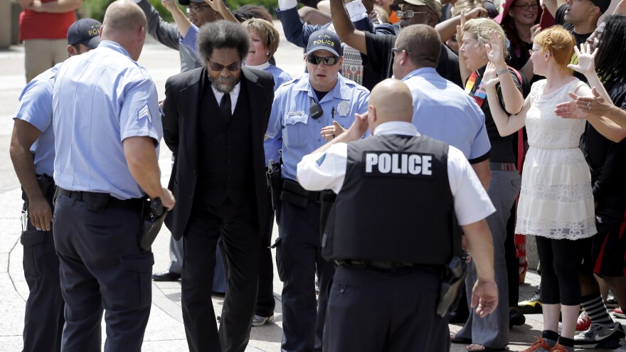 Activist Cornel West is arrested during a protest outside the federal courthouse in St. Louis. He and dozens of other protesters marking the death of Michael Brown in Ferguson, Mo., one year ago.