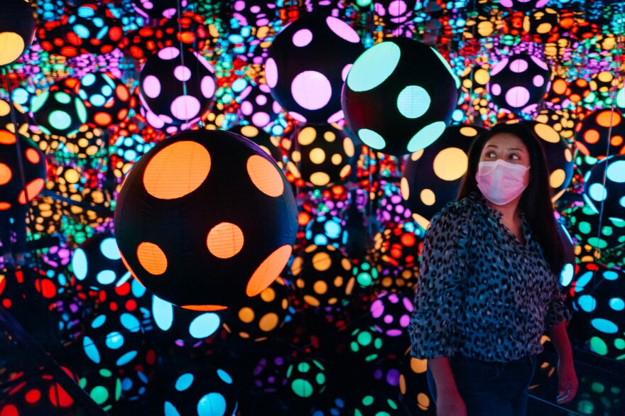 Visitor experiencing Yayoi Kusama's<em> Infinity Mirrored Room—My Heart Is Dancing into the Universe</em> (2018), part of the 2022 exhibition<em> One with Eternity: Yayoi Kusama in the Hirshhorn Collection </em>at the Hirshhorn Museum and Sculpture Garden.