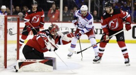 New Jersey Devils goaltender Akira Schmid, front left, makes a save in front of New York Rangers right wing Patrick Kane (88) during the third period of Game 7 of an NHL hockey Stanley Cup first-round playoff series Monday, May 1, 2023, in Newark, N.J