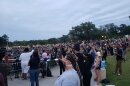 A crowd of people holds up candles.