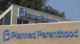 A Planned Parenthood sign is displayed on the outside of a clinic in Indianapolis. On April 3, leaders of the organization said Planned Parenthood is assessing next steps, but hope expanded virtual appointments can help fill some of the gaps caused by the funding freeze.