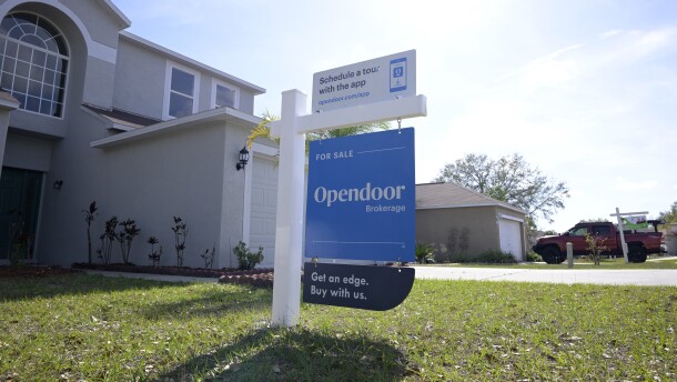 Real estate signs are viewed outside homes for sale