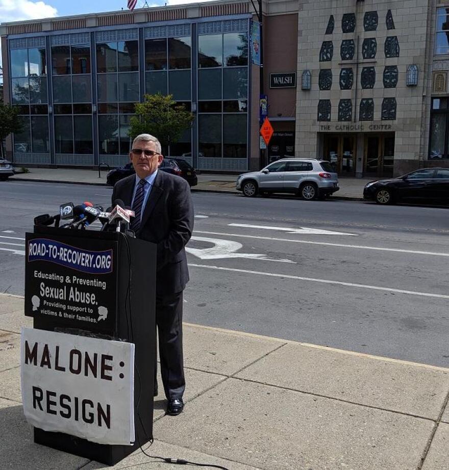 Robert Hoatson of Road to Recovery stands along Main Street in Buffalo Friday morning, across from the Catholic Diocese of Buffalo's headquarters. Hoatson renewed his frequent calls for Bishop Richard Malone's resignation while stating that a similar call to the bishop by the Movement to Restore Trust is "a major move." Credit Michael Mroziak, WBFO