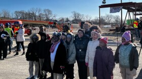 Kansas City Public Schools students pose with superintendent Jennifer Collier ahead of the structure of the new King Empowerment Center.