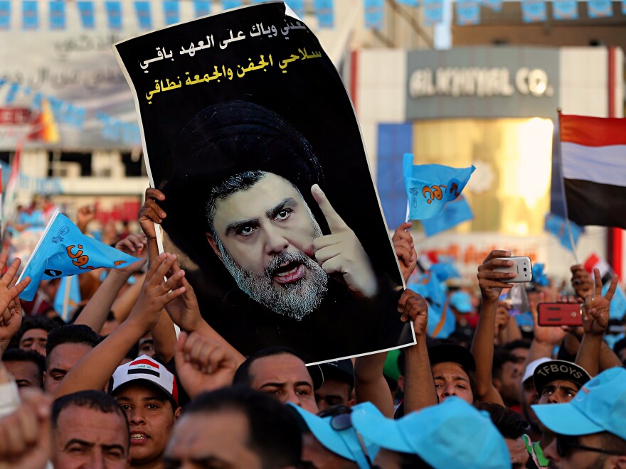 Followers of Shiite cleric Muqtada al-Sadr, seen in the poster, take part in a campaign rally in Baghdad's Tahrir Square on May 4.