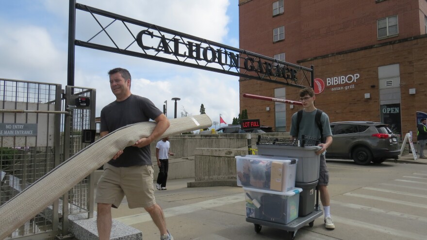 A new student and their parent push and carry items as they move into a dorm at Calhoun Hall at the University of Cincinnati. 