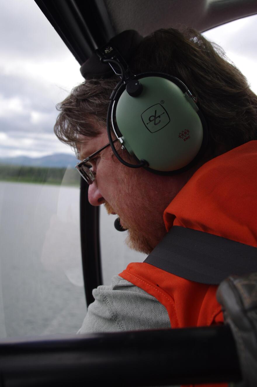 Tim Sands looks down at the Wood River during a June 2015 survey of the Nushagak District. (KDLG photo)