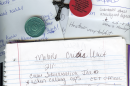 A photo of a notebook, paper, a cross, and sobriety chips.