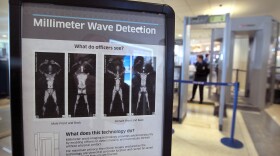 A sign informs travelers about Millimeter Wave Detection technology used in full body scanners at Midway Airport in Chicago. The scanners produce less-revealing images than those that use X-rays.