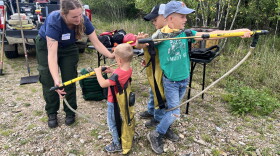 Ashley, from The Nature Conservancy, shows the Jacob, Graham and Jeremy Githens how some of the gear is used in prescribed burns.