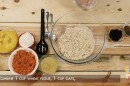 A screenshot from a YouTube video, with bowls of ingredients set out on a table to make oatmeal carrot raisin muffins.