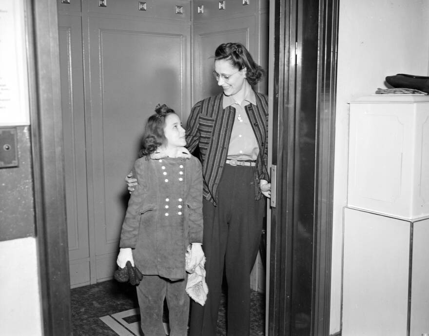 You may be a hero to the girl or boy next door: Trim in Slacks, Miss Lois Jean DeVore is a heroine to Donna Rae Miller. Imagine making an elevator go up and down like that! 1943