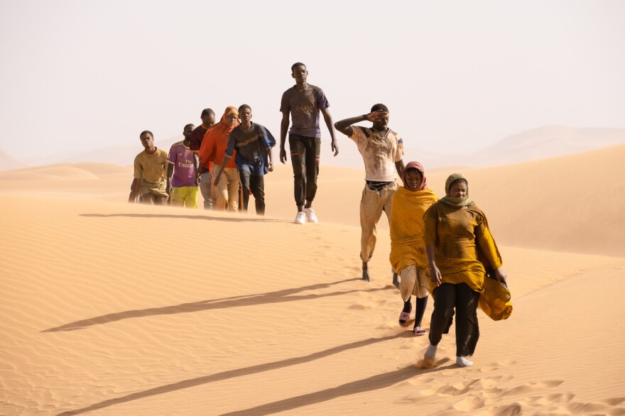 Seydou (Seydou Sarr, in gray) crosses the desert in <em>Io Capitano.</em>