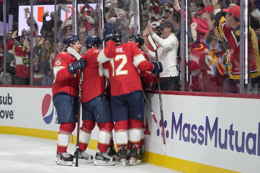 Teammates mob Florida Panthers left wing Ryan Lomberg after he scored during the second period of Game 4 of the NHL hockey Stanley Cup Eastern Conference finals against the Carolina Hurricanes, Wednesday, May 24, 2023, in Sunrise, Fla.
